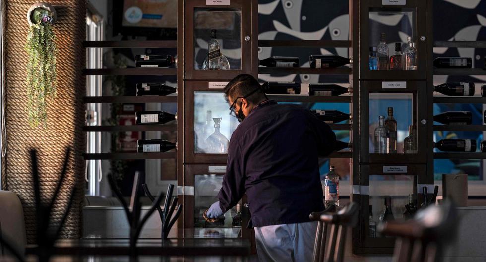 Imagen referencial del 12 de junio de 2020. Un empleado de un restaurante verifica los últimos detalles antes de abrir en una ciudad de México. (AFP / Guillermo ARIAS).