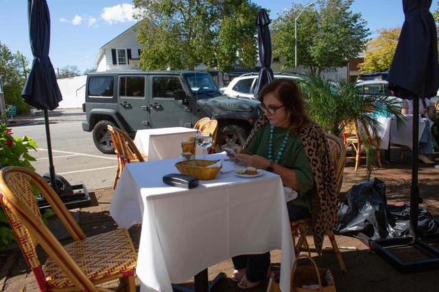 Una mujer es vista sentada en un restaurante en Southampton, el enclave más poblado de los Hamptons, Nueva York. (AFP / Kena Betancur).