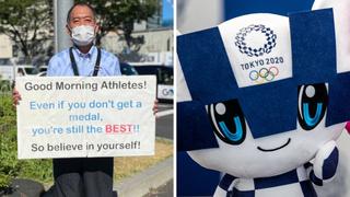Hombre da ánimos a los deportistas alojados en la Villa Olímpica de Tokio con carteles llenos de mensajes positivos