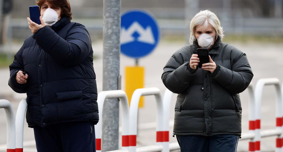Los residentes con máscara respiratoria se muestran en la entrada de la pequeña ciudad de Casalpusterlengo, al sureste de Milán. A la sombra de un nuevo brote de coronavirus, Italia tomó medidas drásticas de contención. (AFP)