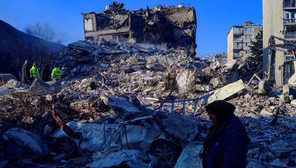 Una mujer camina entre los escombros de un edificio derrumbado en Hatay, el 10 de febrero de 2023, cuatro días después del terremoto de magnitud 7,8 que mató a más de 11.200 personas. (Foto de Yasin AKGUL / AFP)