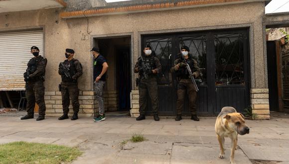 Oficiales de policía montan guardia frente a la casa de Joaquín Aquino, también conocido como El Paisa, acusado de distribuir cocaína adulterada en José C. Paz, provincia de Buenos Aires, Argentina. (Foto: Tomas CUESTA / AFP)