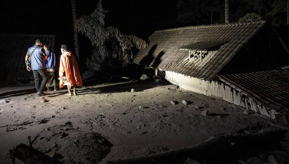 Los aldeanos y rescatistas inspeccionan un área cubierta de cenizas volcánicas en la aldea de Sumber Wuluh, en Lumajang, el 5 de diciembre de 2021, en un intento de encontrar sobrevivientes o cuerpos después de la erupción del volcán Semeru. (Foto de JUNI KRISWANTO / AFP)