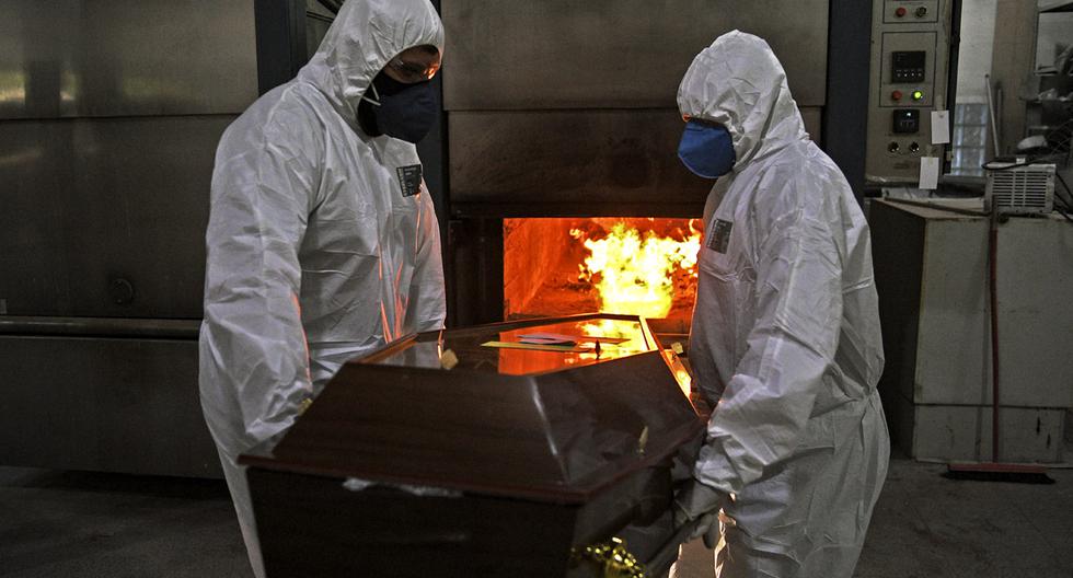 Imagen referencial. Trabajadores, que usan equipos de protección por el coronavirus, empujan un cadáver al horno de su crematorio en el cementerio de Sao Francisco Xavier, en Río de Janeiro, Brasil. (AFP/CARL DE SOUZA).