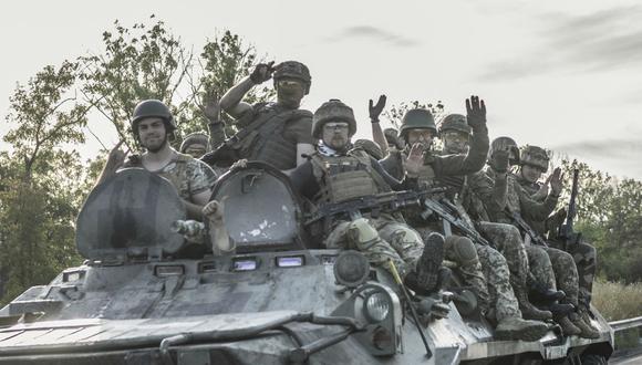 Los soldados ucranianos se sientan en la parte superior de un vehículo blindado mientras se dirige al frente en las afueras de Bakhmut, en el este de Ucrania, el 30 de julio de 2022, cuando la guerra entre Rusia y Ucrania entra en su día 156. (Foto de BULENT KILIC / AFP)