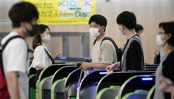 Imagen referencial. Los viajeros con mascarillas contra el coronavirus caminan a través de las puertas de boletos en la estación de Shinjuku en Tokio, Japón, el 10 de julio de 2020. (EFE/EPA/FRANCK ROBICHON).