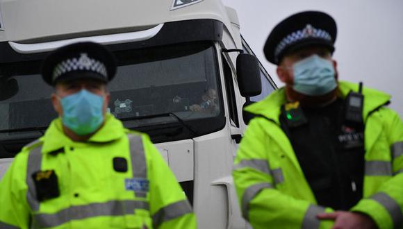 Los agentes de policía forman un cordón en la entrada del puerto de Dover, en Kent, sureste de Inglaterra, el 23 de diciembre de 2020, después de que el Reino Unido y Francia acordaran un protocolo para reabrir la frontera para la carga acompañada que llega a Francia desde el Reino Unido. (Foto de JUSTIN TALLIS / AFP)