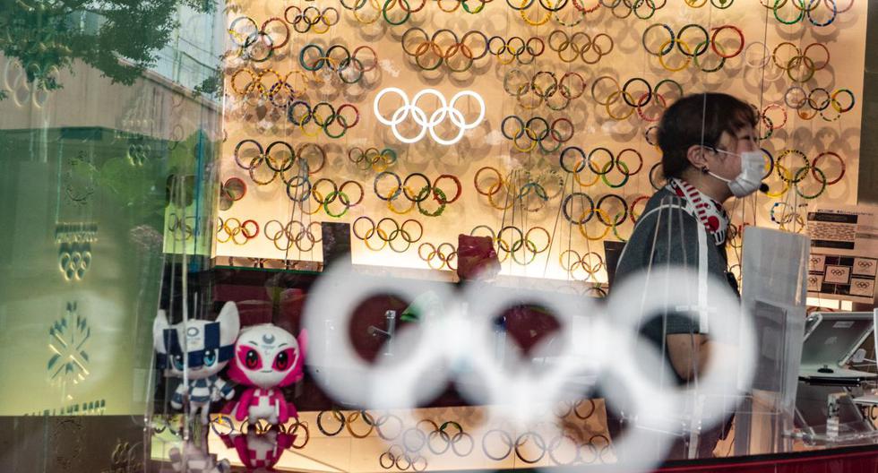 Se ve a un empleado entre los adornos de los Juegos Olímpicos Tokio 2020, el 8 de julio de 2021. (Philip FONG / AFP).