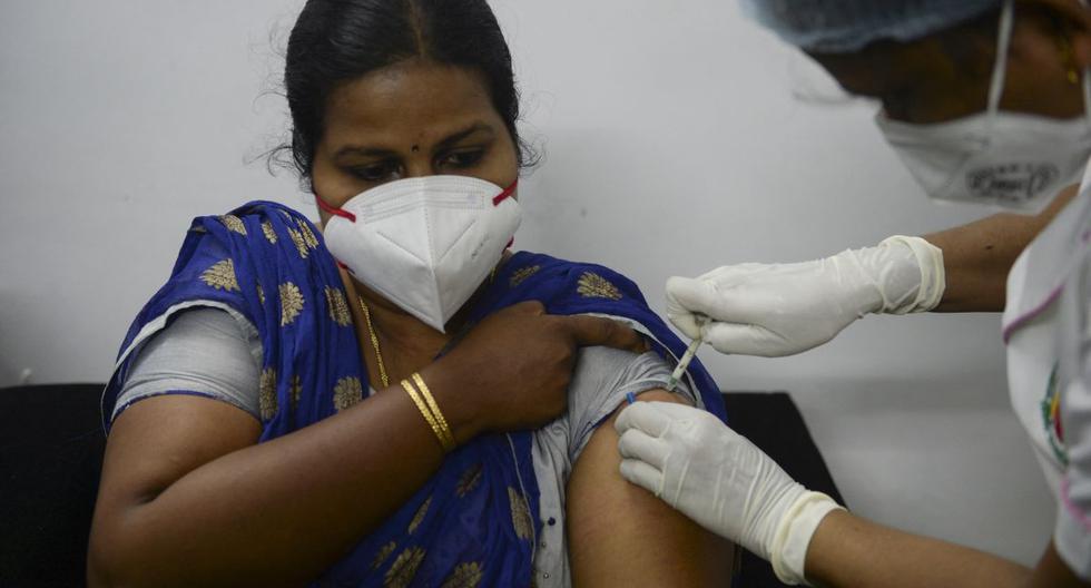 Personal sanitario inocula a una mujer con la vacuna contra el coronavirus de Covaxin en un hospital de la India. (Foto de Arun SANKAR / AFP).