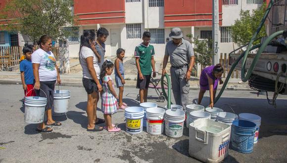Residentes hacen cola para recoger agua limpia de un camión cisterna en el municipio de García, al noroeste del área metropolitana de Monterrey, estado de Nuevo León, México, el 8 de junio de 2022. (Foto de Julio Cesar AGUILAR / AFP)