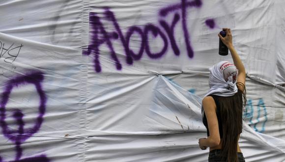 Una mujer pinta un graffiti durante una manifestación exigiendo la despenalización del aborto durante el Día Mundial de Acción por el Aborto Legal y Seguro en América Latina y el Caribe en Bogotá el 28 de septiembre de 2021. (Foto: Juan BARRETO / AFP)