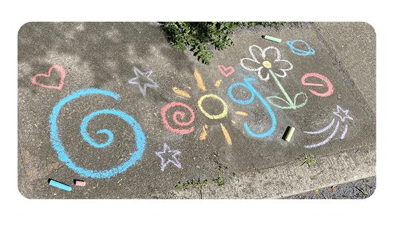 Google presenta este doodle con un diseño de flores, estrellas y soles dibujados con tizas sobre suelo gris que se ha llenado de colores. (Captura / Google)