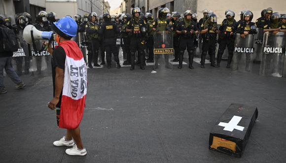 La policía antidisturbios hace guardia mientras los manifestantes actúan durante una protesta contra el gobierno de la presidenta de Perú, Dina Boluarte, el 9 de febrero de 2023, en Lima. (Foto por ERNESTO BENAVIDES / AFP)