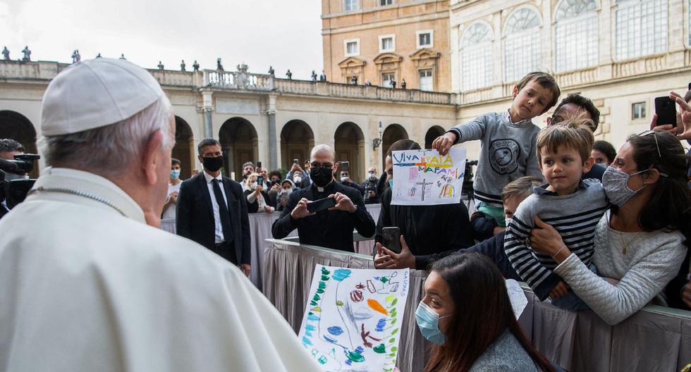 Imagen muestra a niños entregándole dibujos al papa Francisco cuando llega al patio de San Dámaso en el Vaticano para reanudar su audiencia general semanal al aire libre con el público después de una ausencia de seis meses debido a la crisis del coronavirus. (VATICAN MEDIA / AFP).